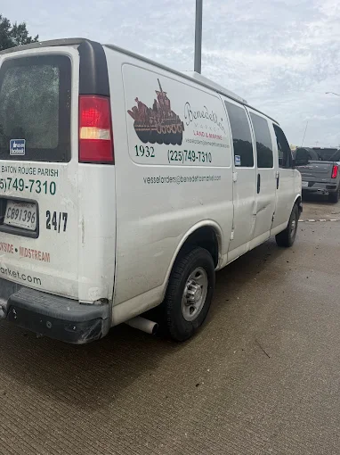 White cargo van stopped on a highway roadway with body damage along the side